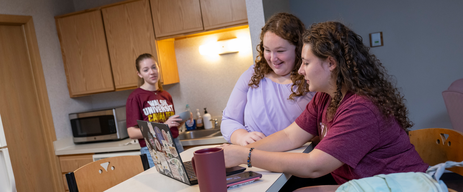 Three students working on an assignment together in the residence hall.