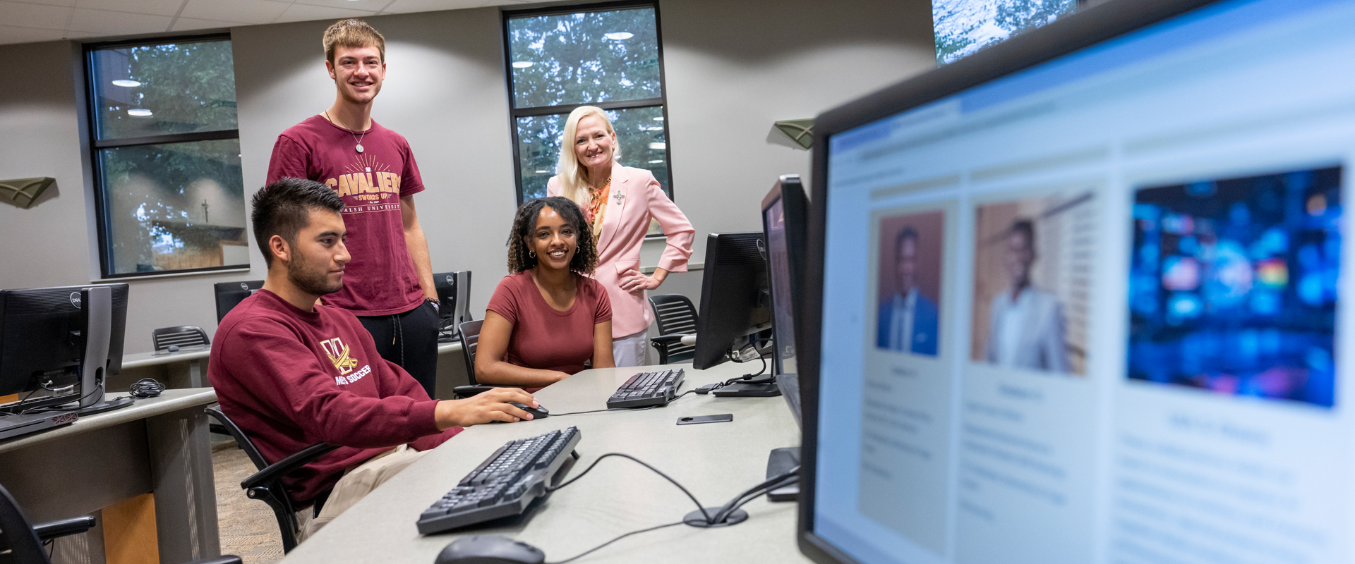A professor instructs two students in a classroom setting