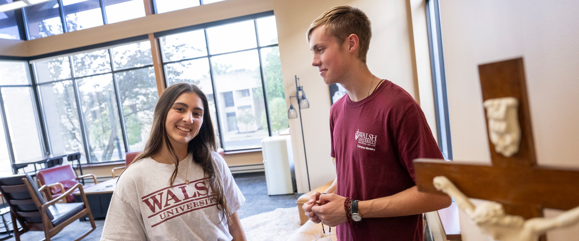 Two students having a conversation in the Campus Ministry Lounge.