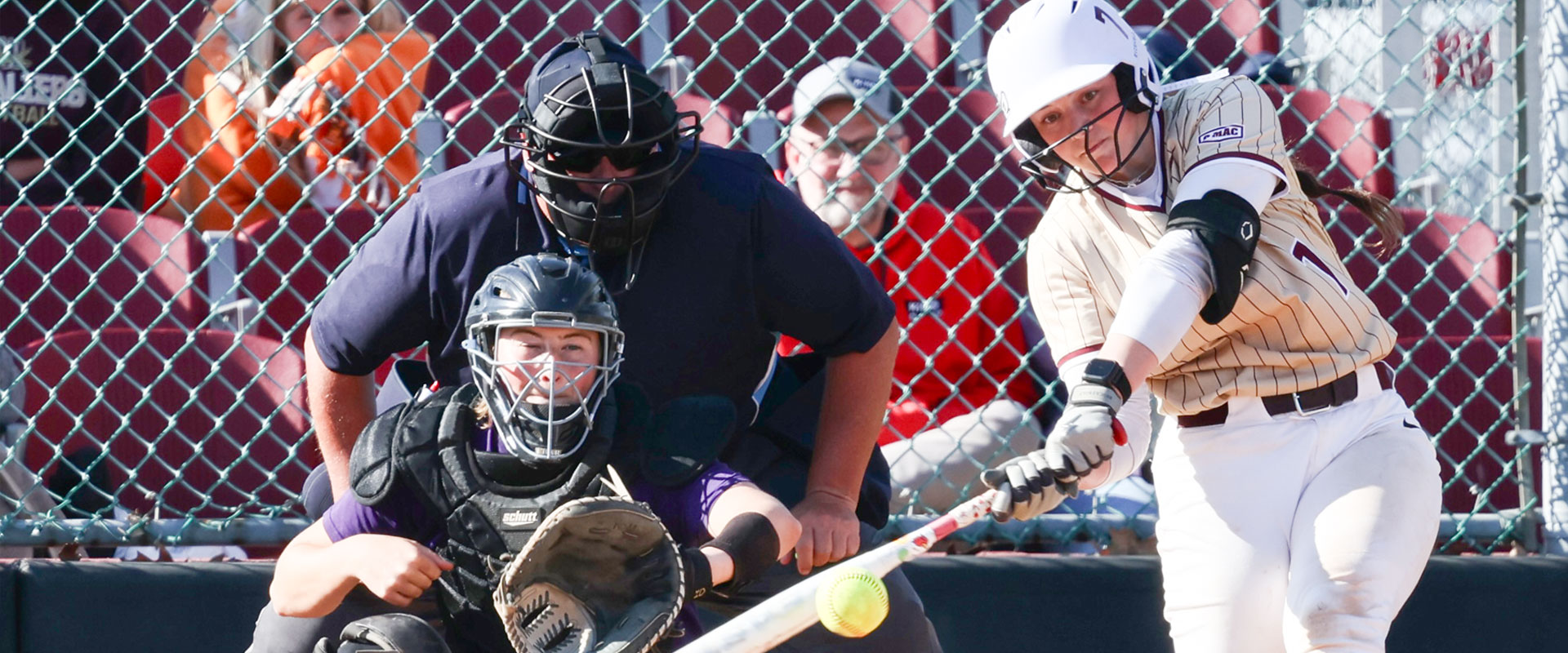 Walsh University softball player in the act of swinging on a pitch.