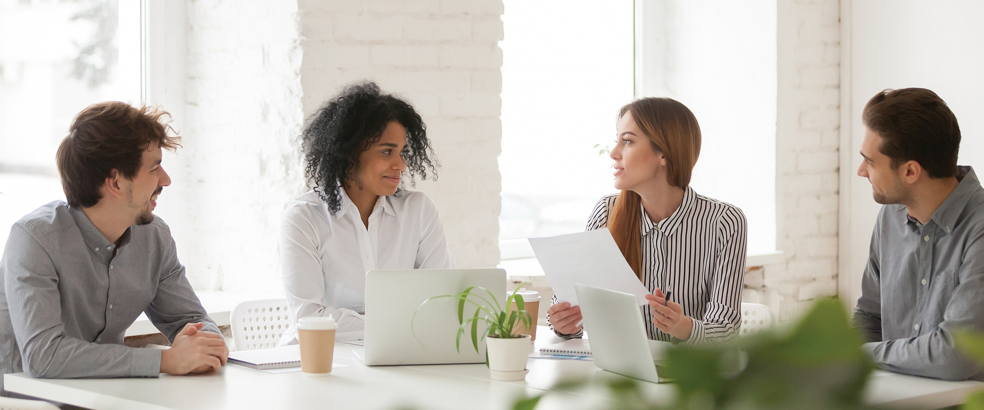 photo of four co-workers gathered around a conference table