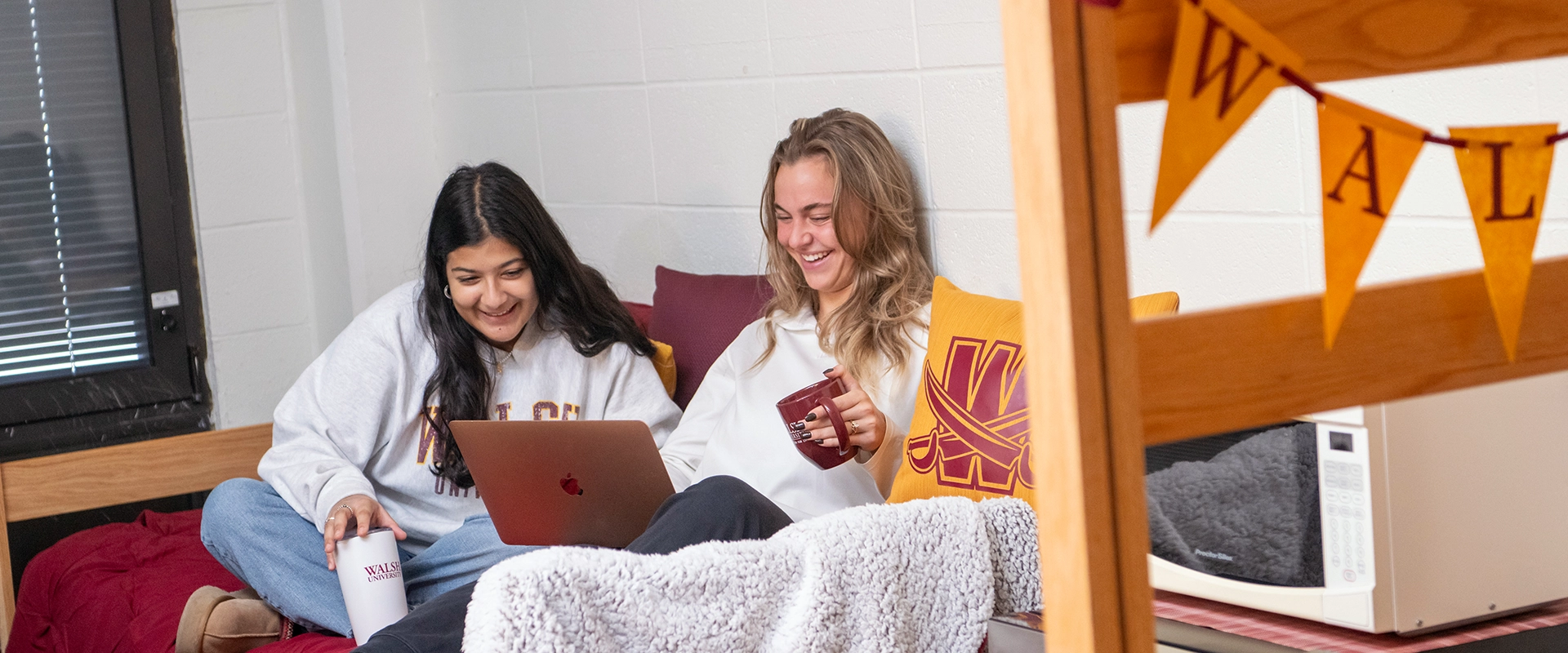 Photo of two students spending time together in a dorm room
