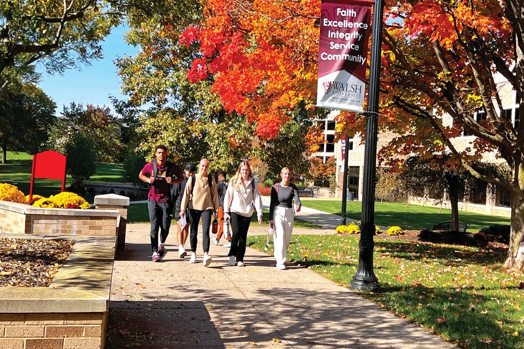 Photo of a group of Walsh students walking on campus in the Fall.