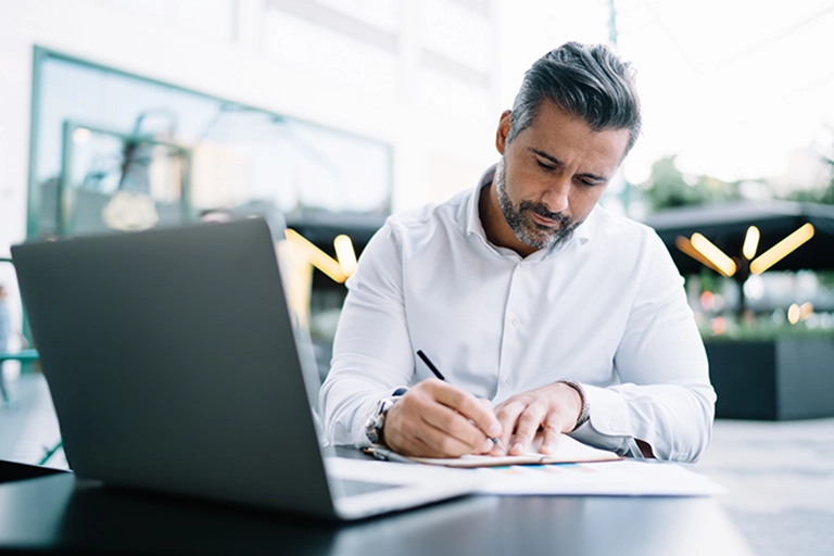 photo of a man working on a laptop in a public space 